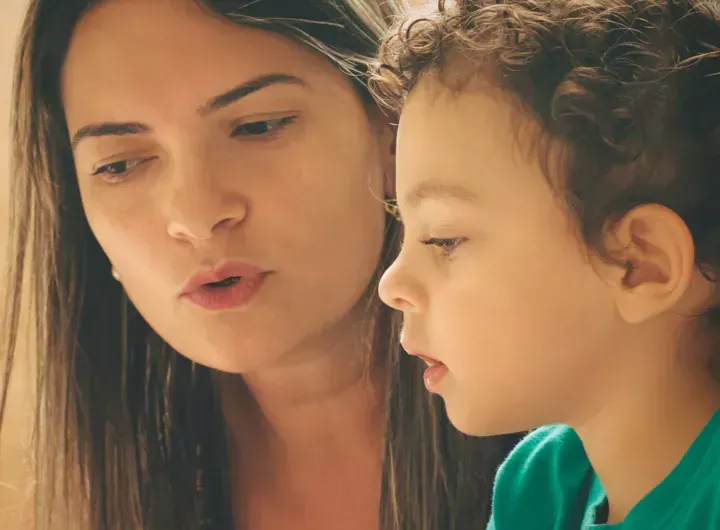 mother talks to young child as they are looking at something together