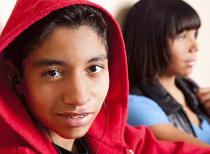 teenage boy wearing hoodie smiling at camera, Adolescente llevando sudadera sonriendo hacia la cámara.