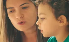 mother talks to young child as they are looking at something together