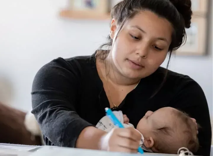 blug-hubmoment-woman-holding-pen-and-baby-720x530px.webp