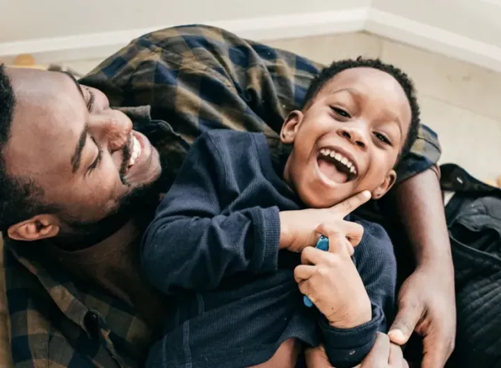 img-father-and-son-on-cauch-laughing-1200x630px.webp