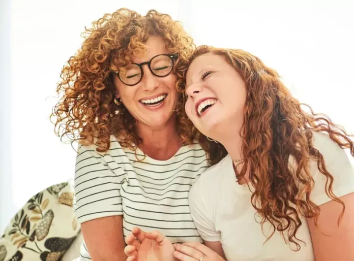 img-mother-and-daughter-on-cauch-laughing-1200x630px.webp