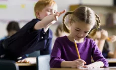 boy about to pull girl's hair in the classroom